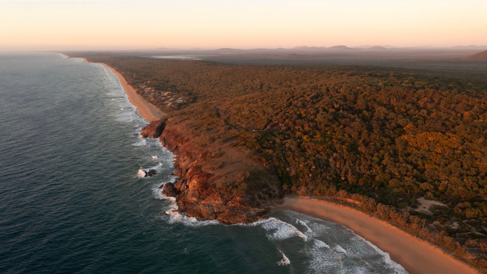 The Red Rock coastline at dusk, both beaches and the coast running north
